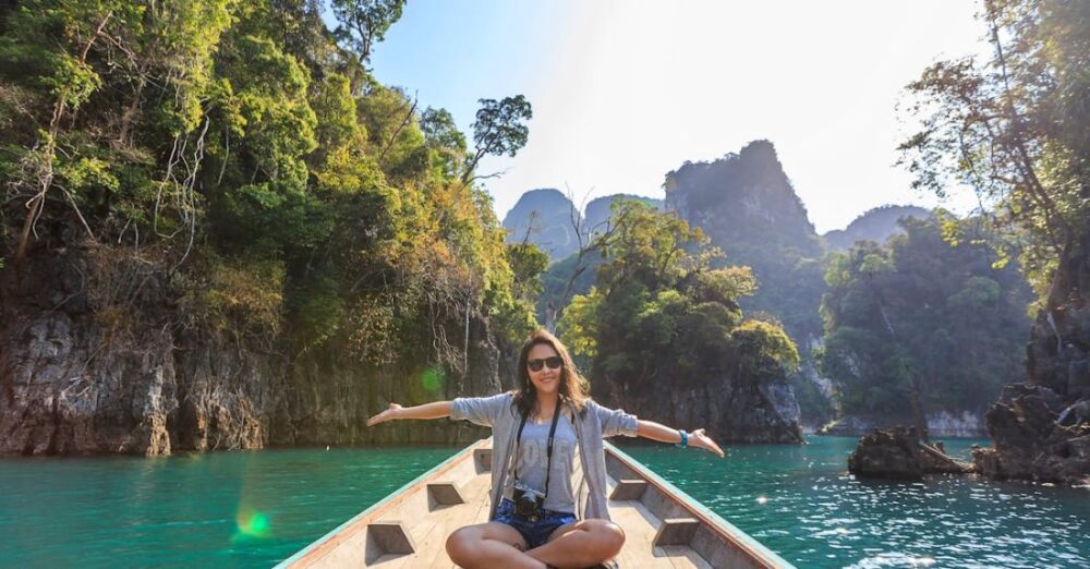 Trip - Photo of Woman Sitting on Boat Spreading Her Arms